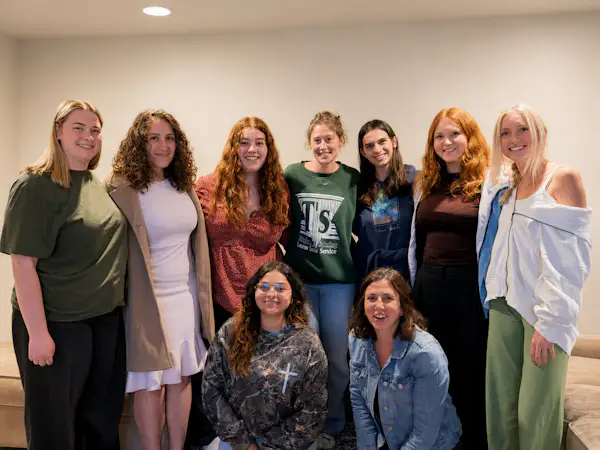 A group of college students pose for a group photo indoors