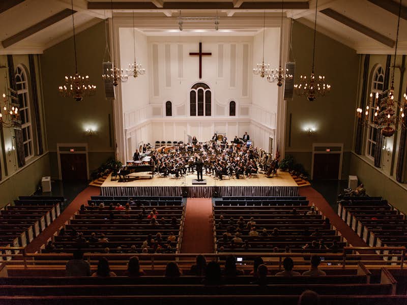 A wide angle view of the A J Memorial Chapel with musicians playing on the stage