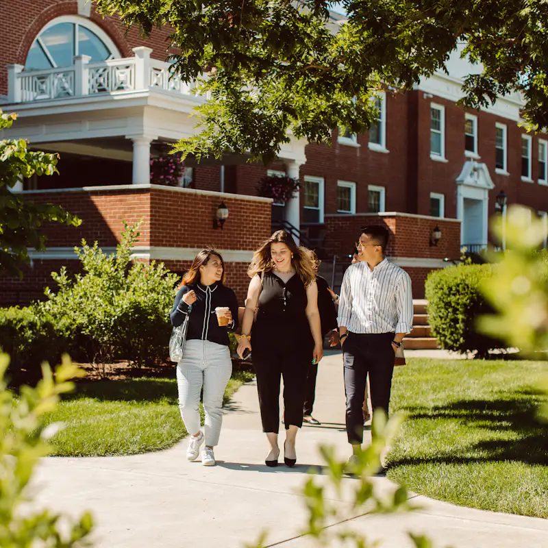 Three students walk out of the campus library