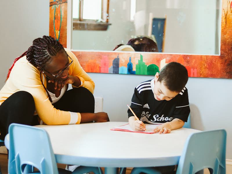 A student helps a young child with homework