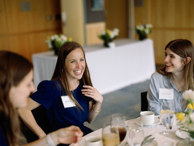 A lunch guest sits at a table and smiles