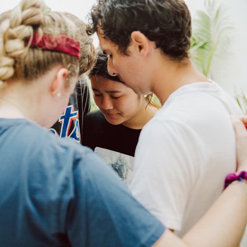 Students pray together while on a missions trip