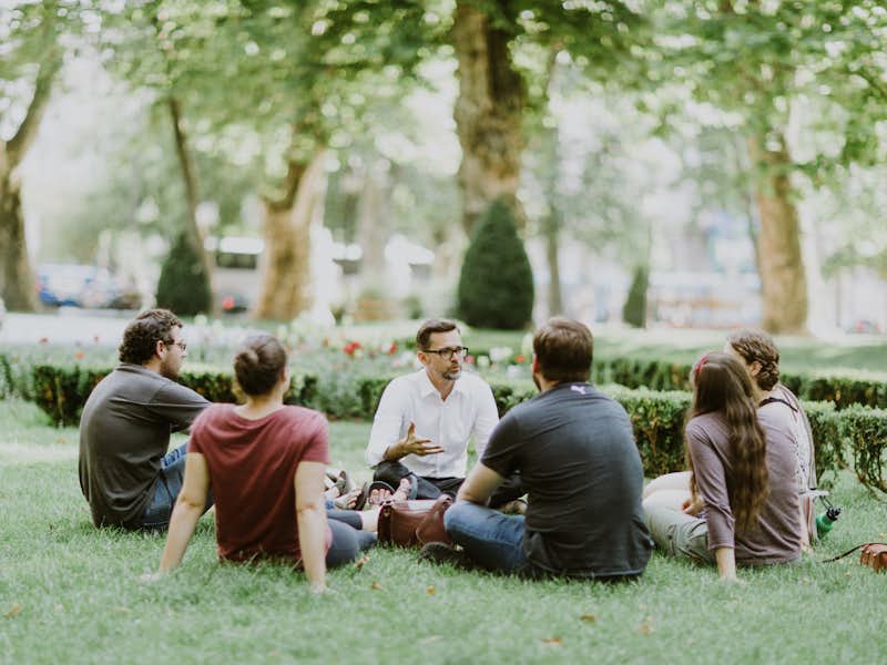 Students sitting in a circle on the ground in Croatia learning from a professor