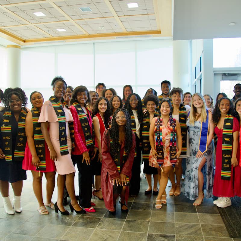 MIO and ISO graduating students take a group photo with their graduation regalia