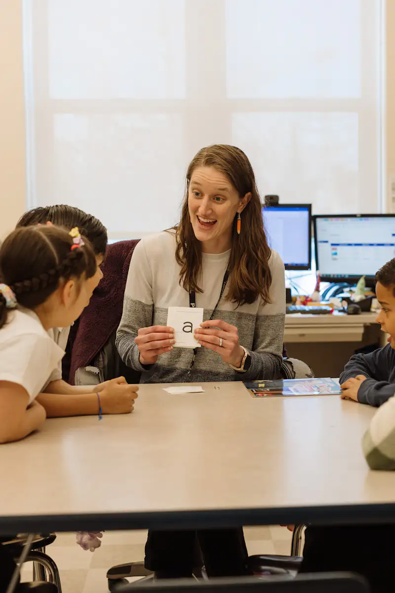 Student teacher works with a small group of students in a classroom.