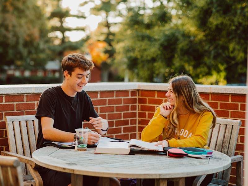 Two Gordon College students studying outside.