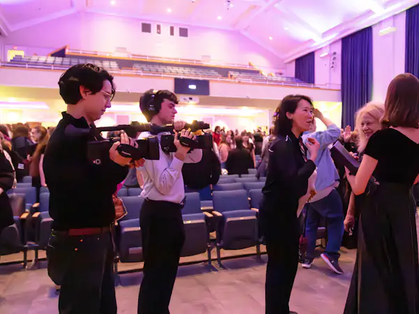 Film students interview choir performers after their show on stage
