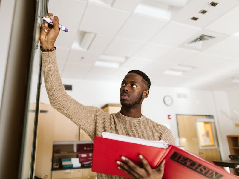 Physics student writes on a whiteboard