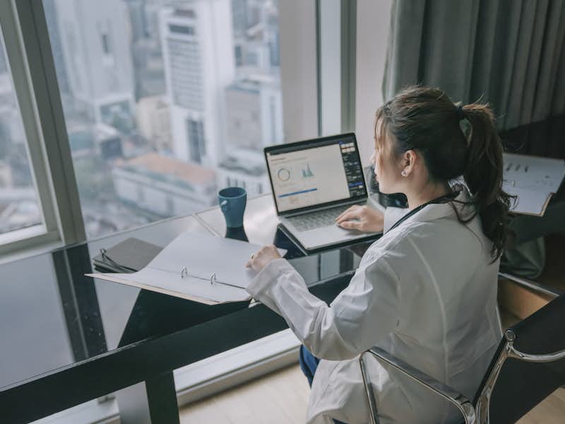 A Public Health Graduate student works at a desk in the city.