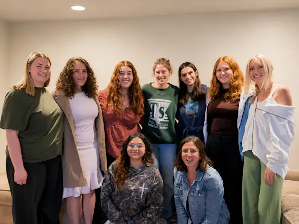 A group of college students pose for a group photo indoors