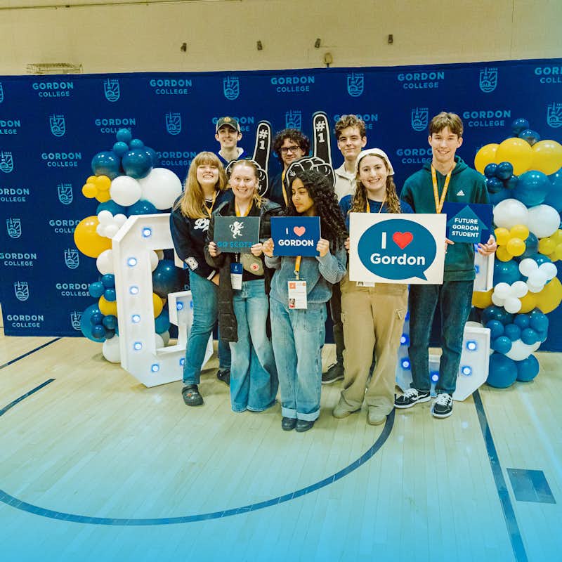 Group of incoming students pose with Gordon signs
