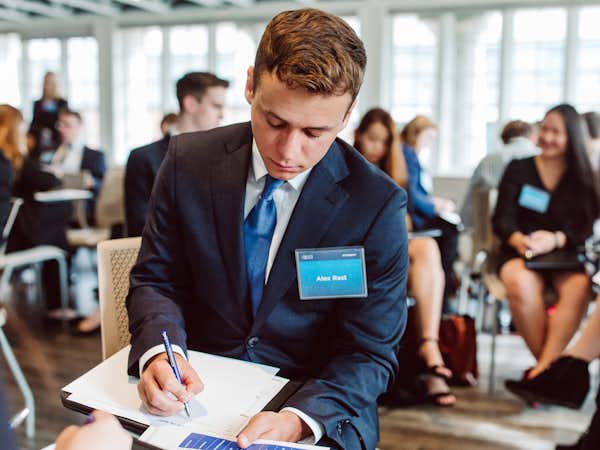 A student takes notes at a career networking event