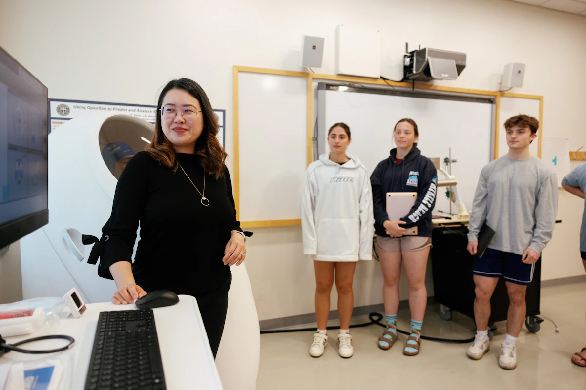 A woman runs a medical test while medical students watch.