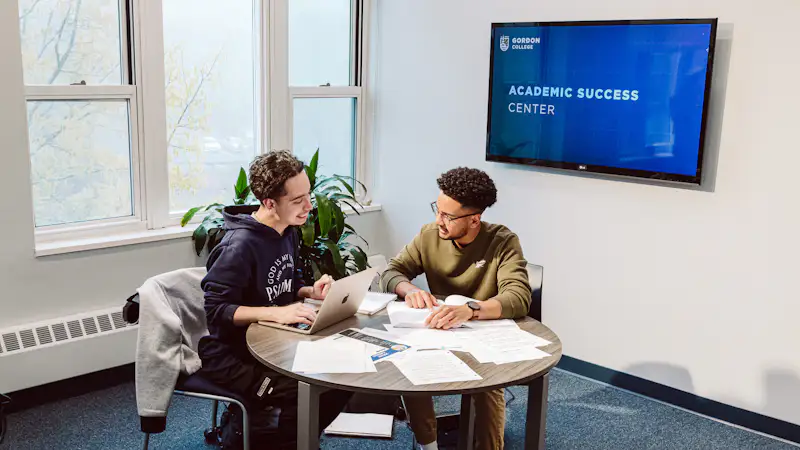 Two students sit at a table and study together